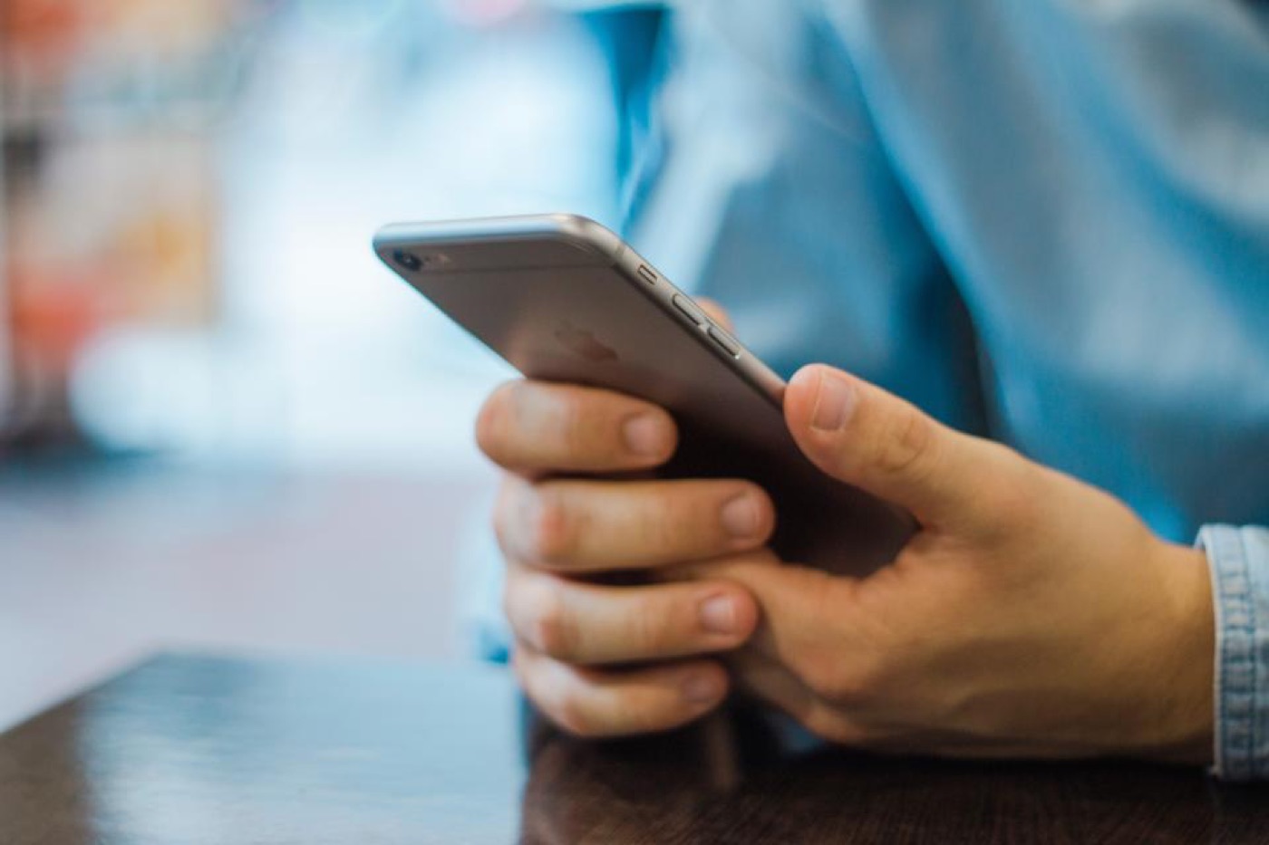 Hands holding a smartphone at a table