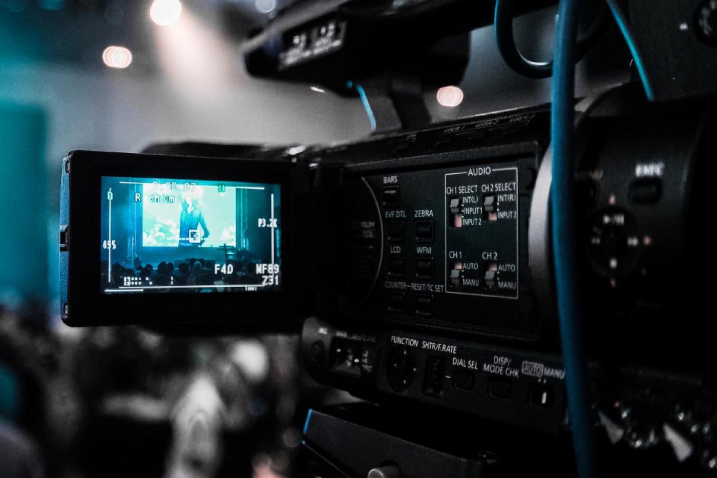 A broadcast video camera with its viewfinder screen lit